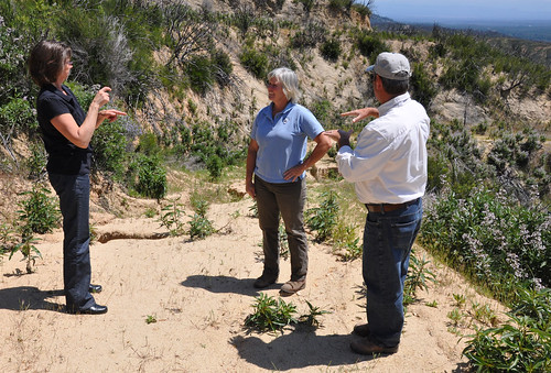 A sign language interpreter facilitates communication as Bob Bailey explains how soil erosion concerns on an access road might be addressed.  