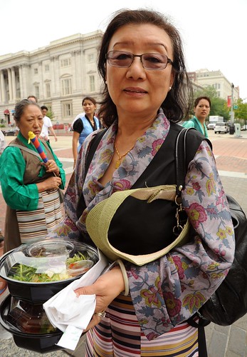 Mrs. Yuthok, carrying a salad lunch, wears a black chuba and restrained artistic floral blouse, with apron, Kalachakra for World Peace, Happy Birthday to the Dalai Lama Parade, Washington D.C., USA by Wonderlane
