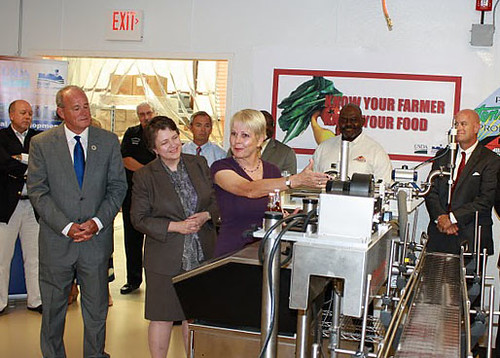 Tennessee Gourmet Co-Owner and Cumberland Culinary Center Manager Sue Sykes shows off new equipment purchased with help from a USDA Rural Business Enterprise Grant at Cumberland University's Cumberland Culinary Center on 7/12/2011. Seen behind her are USDA RD Business Programs Director for Tennessee Dan Beasley, USDA Rural Development Tennessee State Director Bobby Goode, Tennessee Gourmet Co-Owner Gary Doomer, Agriculture Deputy Secretary Kathleen Merrigan, Wilson County Mayor Randall Hutto, USDA RD Nashville Area Director Christopher Westbrook and Ron Reed's Signature Barbeque Sauce Company Owner Ron Reed, Cumberland University School of Business Dean Paul Stumb, USDA FSA State Director Gene Davidson and USDA Tennessee State Conservationist Kevin Brown.