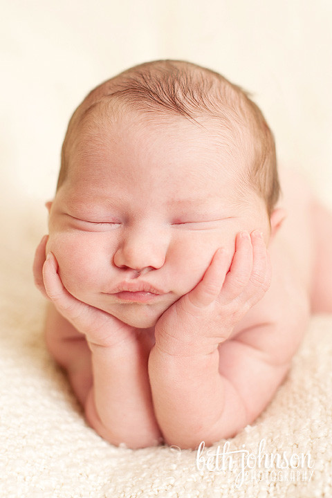 newborn baby girl with head on hands pose