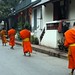 Filas de monges a passos rápidos e pés descalços