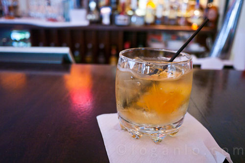 Glass of rum on the rocks with a thick slice of orange at Salute! NYC