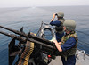 Sailors man a .50-caliber machine gun during a security watch aboard USS Truxtun