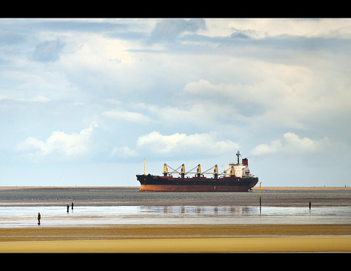 Big ship sails into the river Mersey watched over by the Ironmen of Crosby by Ianmoran1970