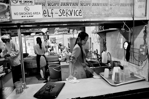 A lady clearing up the counter after the stall closing time.