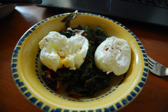 Poached eggs on kale, tomato and onion