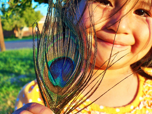 A young Tohono O’odham girl smiles and shows off a peacock feather.  The Tohono O’odham Community Action is working to create a healthy, sustainable and culturally-vital community for the Tohono O’odham Nation’s 28,000 members.  Photo by Cheryl Maze Walker.