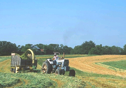 Harvesting hay from a field that is being farmed along the contour of the land.  FSA loan programs provide America's farm families with the support they need to feed America and the world. This is a USDA photo from NRCS.  