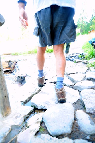 Walking on stones, hot mineral water flowing, a man in shorts, socks, climbing boots, hose, trees,  Breitenbush Hot Springs, Breitenbush, Oregon, USA by Wonderlane