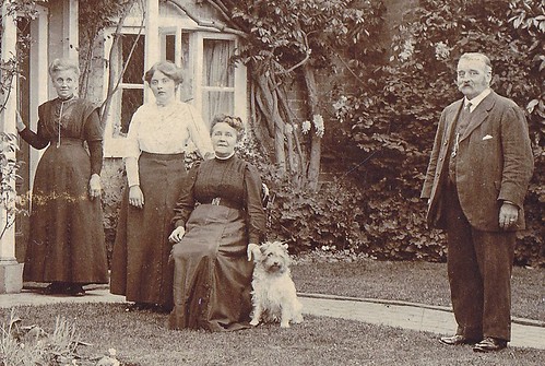 Family and dog in their garden at home. 1900s (enlarged detail)