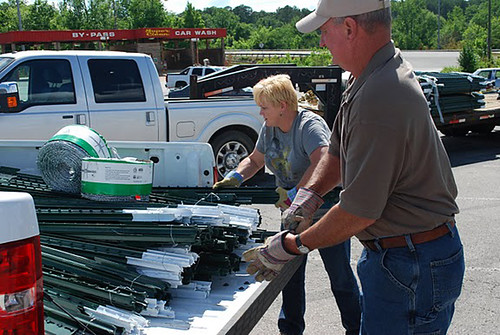 NRCS Soil Conservation Technician Pam Skidmore (l) helps an area producer load supplies. 
