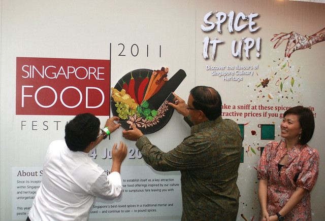 Mr S. Iswaran (with Chef Milind Sovani assisting) placing the final piece on SFF's new logo