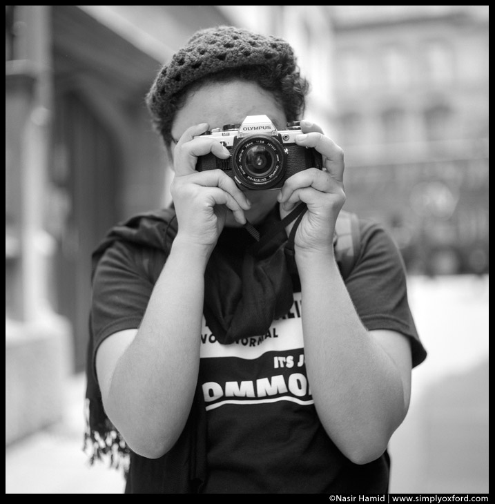 Photographer holding an Olympus film SLR