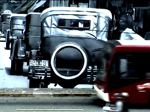 carros antigos e vultos modernos sobre arte mural de Kobra
