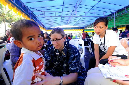 Lt. Stacy Dodt, a doctor embarked aboard the Military Sealift Command hospital ship USNS Mercy (T-AH 19), examines an Indonesian child