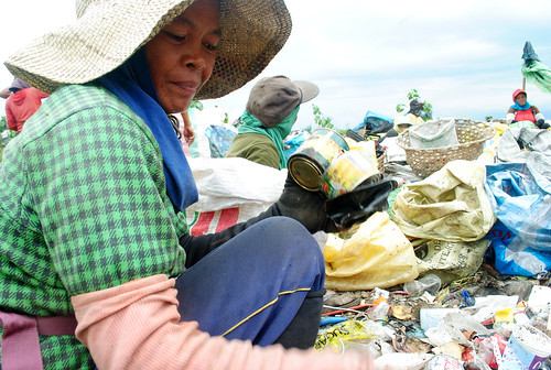 A woman scavenger picks tin cans from the unsegregated bunch of garbage at the Inayawan landfill.