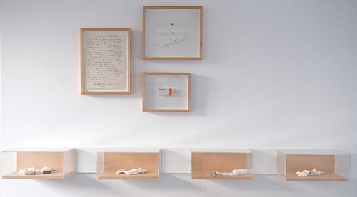 small boxes against a wall with some framed documents