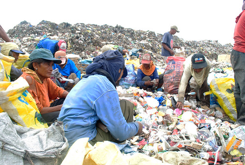 A group of women surround the unsegregated bunch of garbage at the Inayawan landfill to pick cans, aluminums and plastic bottles.