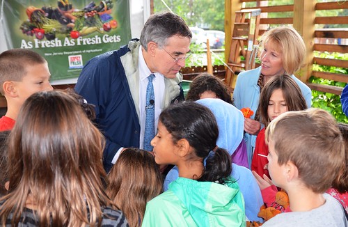 U. S. Representative Rush Holt (left) and USDA Food and Nutrition Service Mid-Atlantic Regional Administrator Pat Dombroski mingle with proud children showing off their school garden before tasting an eatable flower grown just a few feet away.