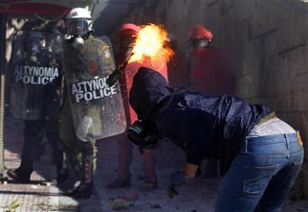 Greek youth tosses petrol bomb at riot police amid general strikes and rebellions in the European country. The Greek government has been forced by the banks to impose austerity on the workers. by Pan-African News Wire File Photos