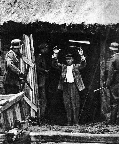 Soldados alemãs, comandados por um oficial, revistam uma cabana de camponeses russos
