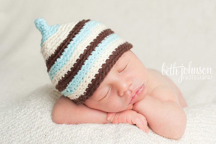 newborn baby boy in brown blue cream pixie hat