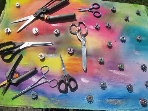 scissors and bobbins on the painted fabric to be sunprinted