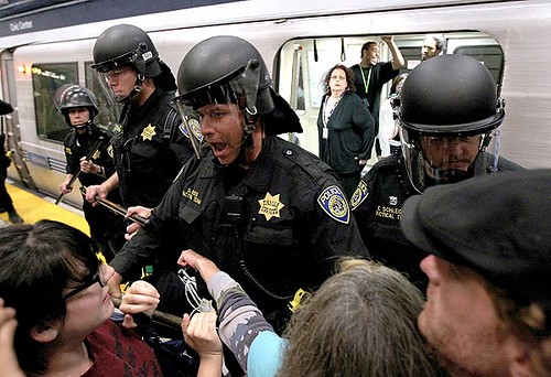 Bay Area Rapid Transit police push back demonstrators who are trying to keep a train from leaving the Civic Center station in San Francisco.