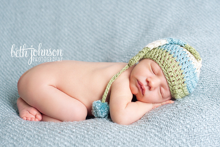 newborn baby boy in blue green and cream elf hat