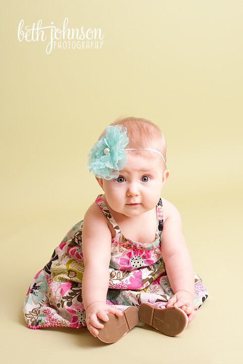 six month old baby girl in photography studio green backdrop