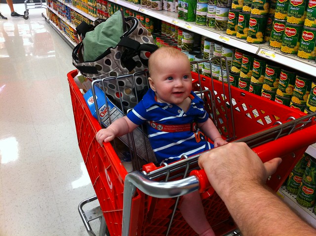 Sitting up like a big boy in the grocery cart.