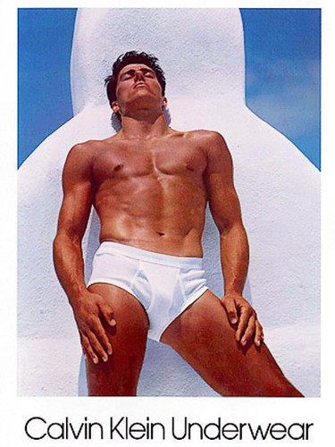 1982 Calvin Klein ad with Tom Hintnaus wearing nothing but a pair of white briefs with his eyes closed against a white and blue background