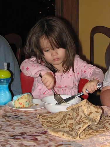 cutting her ice cream into bite-size pieces