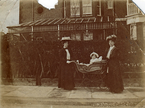 Two ladies and a baby in a pram. 