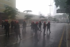 Fru standing off crowd in the rain, Jalan Pudu