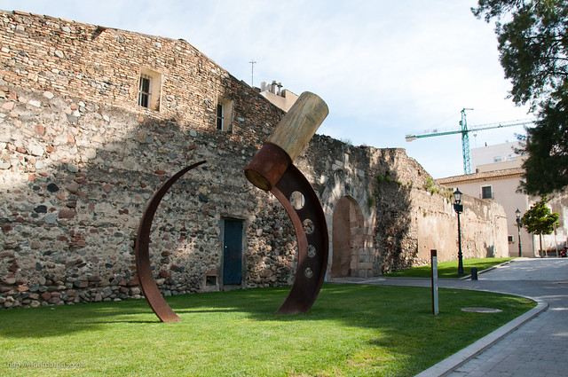 Estela de Fal�: Un monumento frente a los restos de la muralla y una de sus puertas