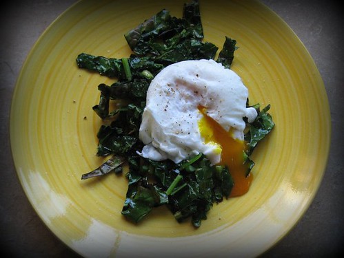 poached egg over kale and garlic scapes