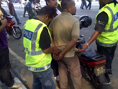 The police mistakenly cuffed and pushed around this man, then released him when they realized he had nothing to do with the Bersih rally
