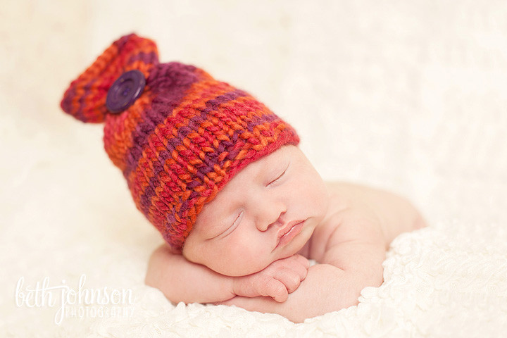 newborn baby girl with orange and purple hat