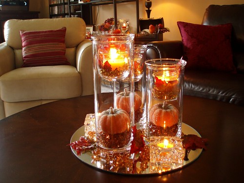 A fall centerpiece for the coffee table is created from three cylinder vases