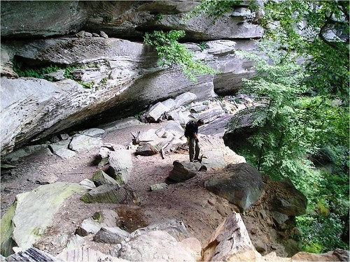 A hiker explores a rock shelter in the Red River Gorge (photo courtesy of Daniel Boone National Forest).