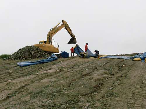 Contractors build an earthen berm to shore up the George H. Nichols Dam as Tropical Storm Irene approaches.