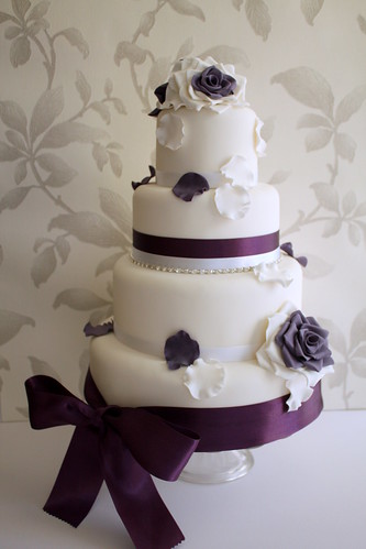 wedding cake with purple ribbon and lace