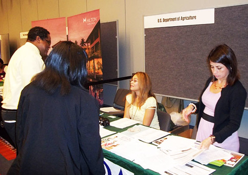 AMS employees at the Congressional Hispanic Caucus Institute career fair. Gilda Villela (left) and Dora Flores (right) hand job fair participants information about AMS.