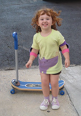 Speck giggling in front of her new skateboard/scooter
