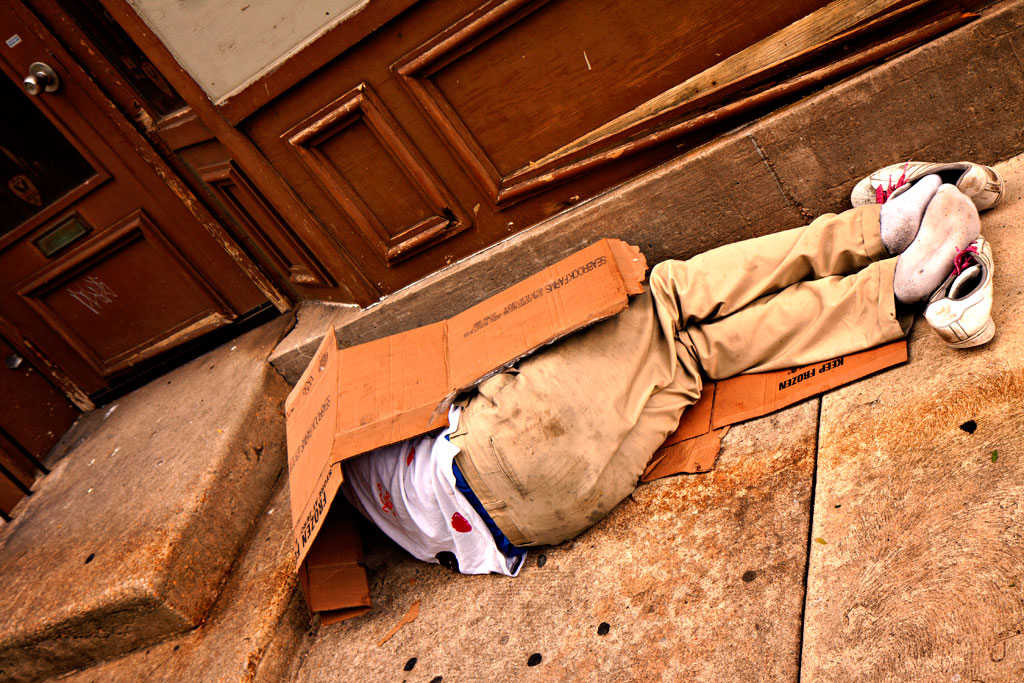 Man-sleeping-in-front-of-brown-building--Center-City