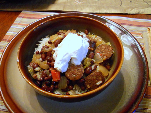 A brown bowl of Cajun fusion chili with Andouille sausage, black beans, and more.