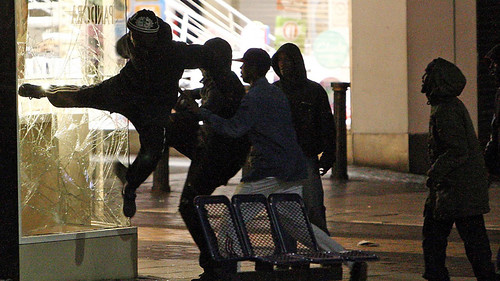 Black youth kick in storefront windows during the rebellion that struck Birmingham, England on August 8, 2011. The nationwide uprising was sparked by the economic crisis and police brutality. by Pan-African News Wire File Photos