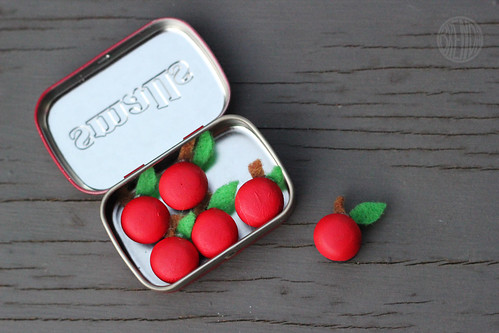 wooden apple magnets displayed in a small Altoid container