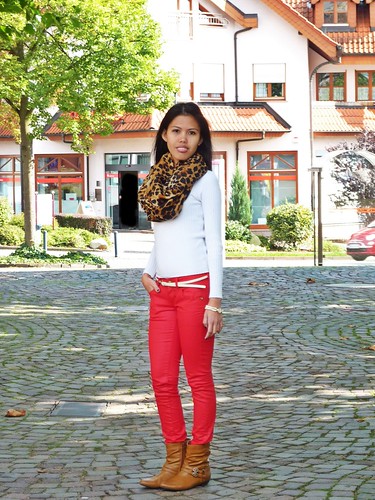 woman wearing colored skinny jeans in bootd with animal print scarf